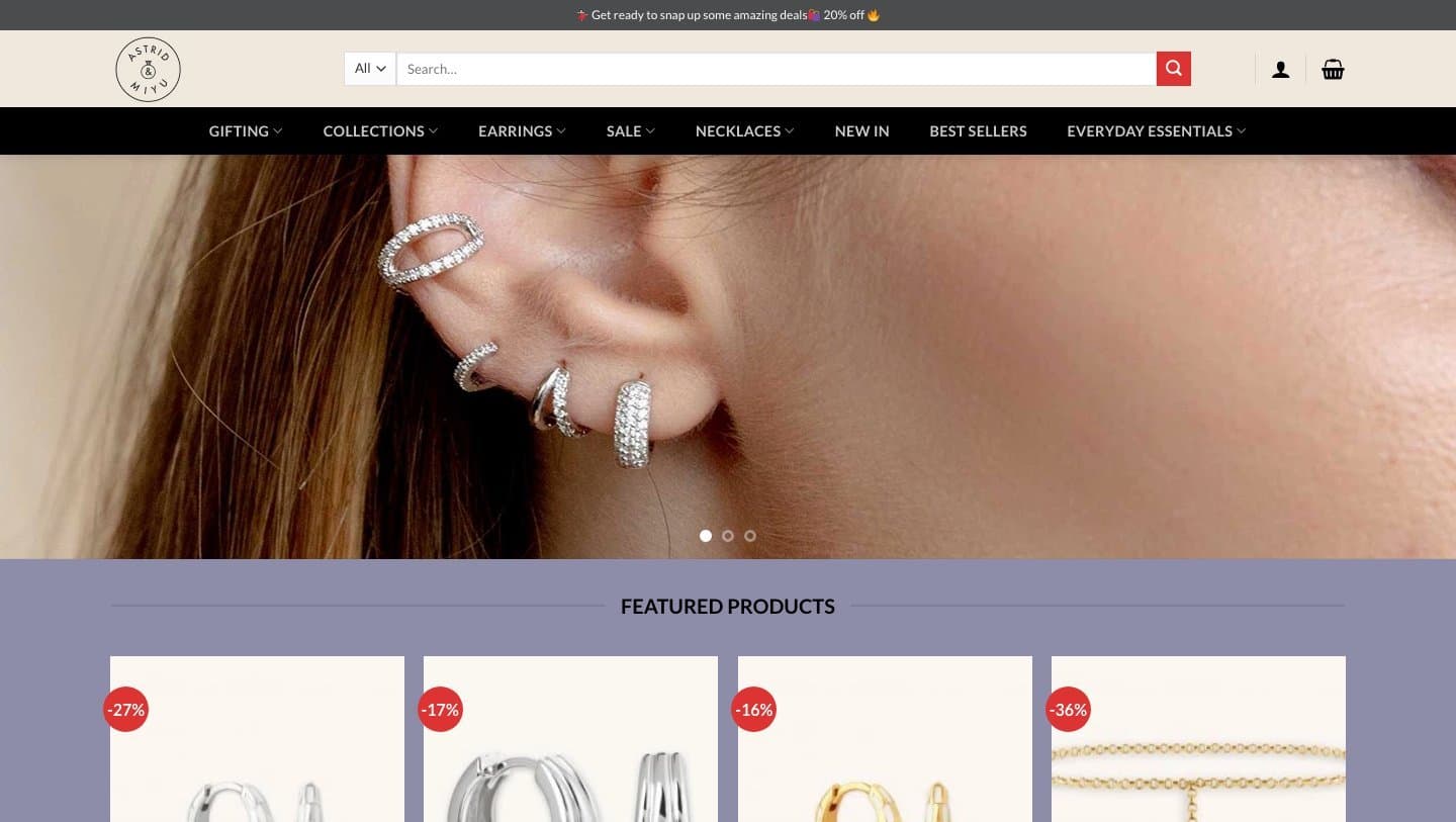 astridandmiyus.com homepage with an Astrid & Miyu logo, ear-stack banner and discounted featured products